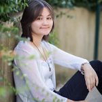 High school senior girl photographed amongst ivy on a concrete background