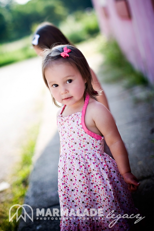 photograph of two sisters near a pink wall