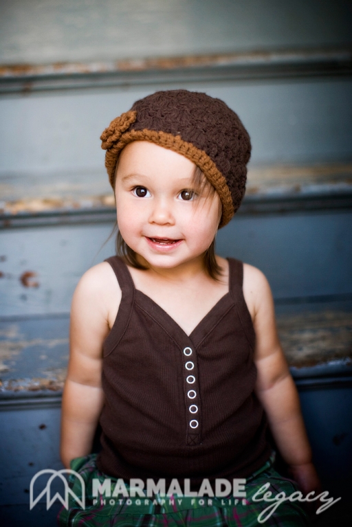 photograph of a child on stairs with a brown knit hat